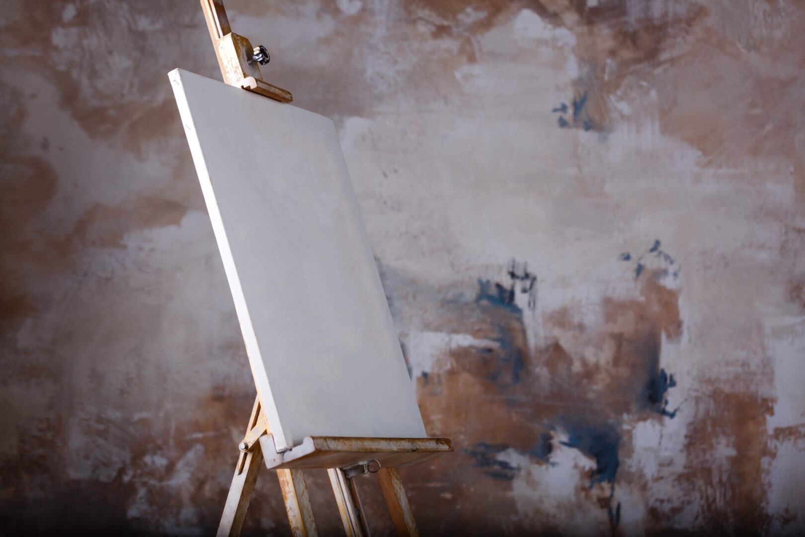 White empty artistic canvas on an easel for drawing images by an artist on a gray background