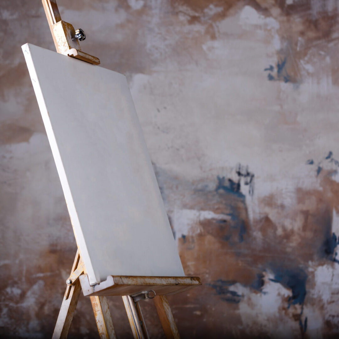 White empty artistic canvas on an easel for drawing images by an artist on a gray background